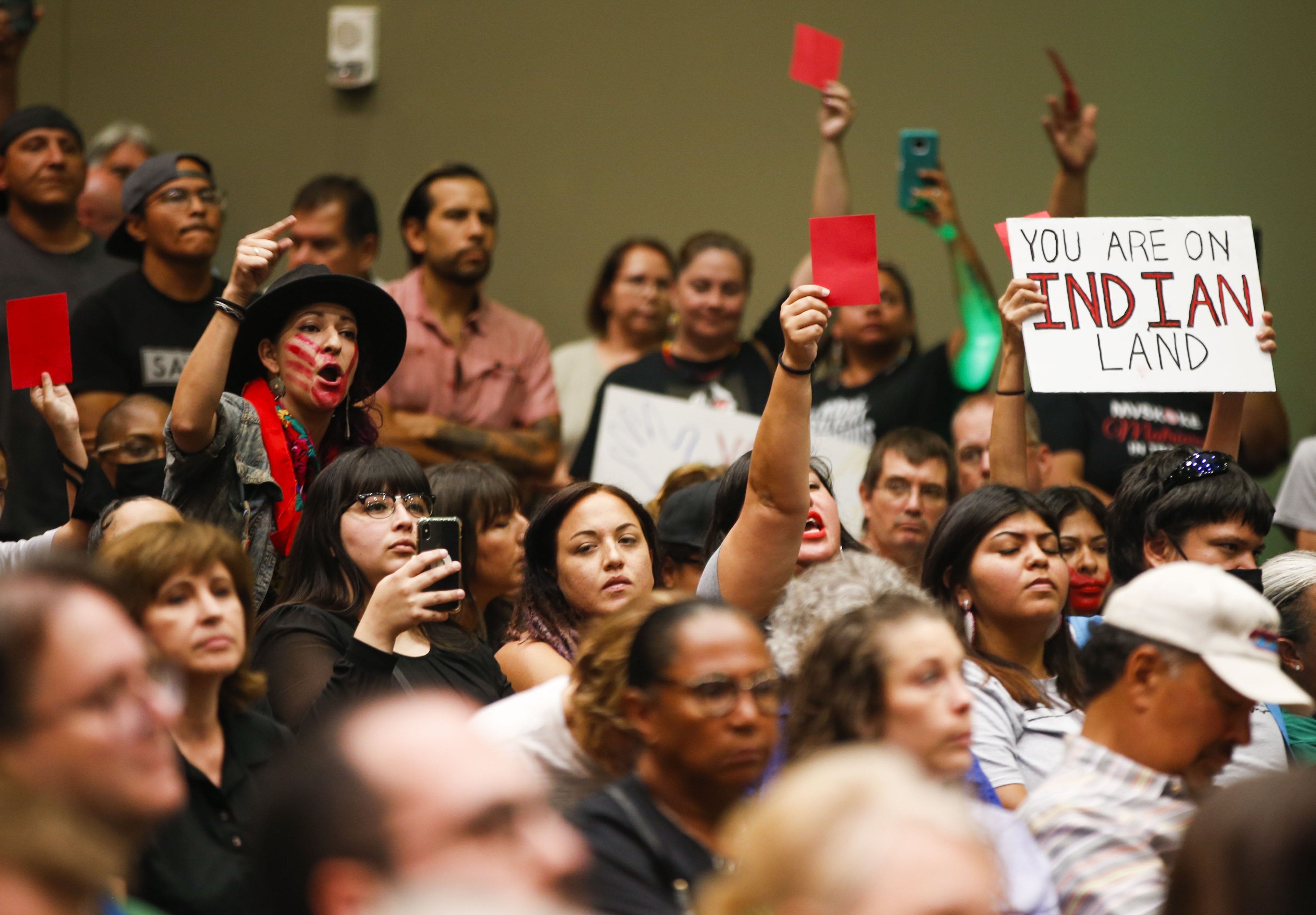 Following a U.S. Supreme Court decision that found that the Muscogee Nation had remained a reservation after Oklahoma became a state, attendees at a panel hold up signs and red cards calling out lies they heard from speakers on July 13, 2021 in Tulsa, Okla.