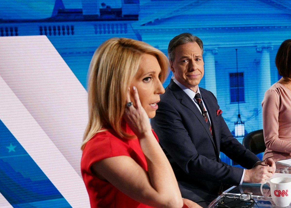 CNN news anchor Jake Tapper (C), flanked by Univision's news anchor Ilia Calderón (R), watches as co-anchor Dana Bash adjusts her ear piece before the start of the 11th Democratic Party 2020 presidential debate with former Vice-President Joe Biden and Vermont Senator Bernie Sanders in a CNN Washington Bureau studio in Washington, DC on March 15, 2020. (Photo by Mandel NGAN / AFP) (Photo by MANDEL NGAN/AFP via Getty Images)