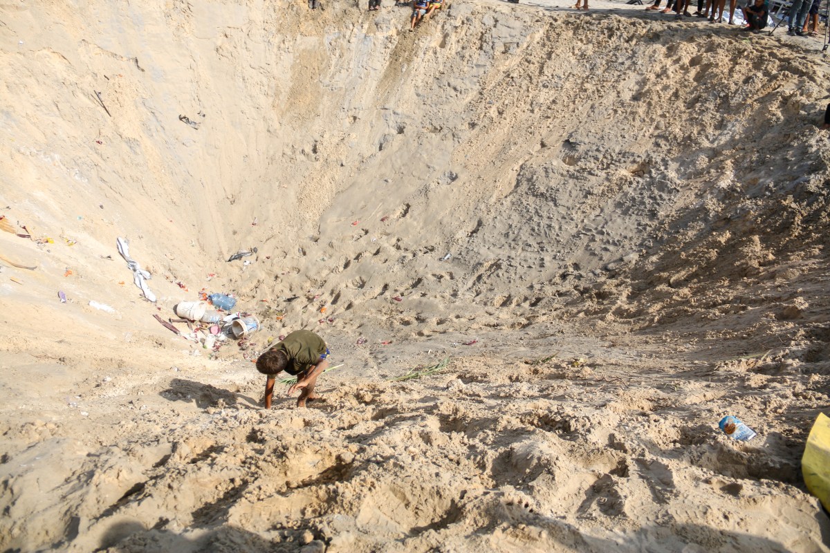 A boy climbs a pit after Israeli airstrikes on the humanitarian area known as Al-Mawasi in Khan Younis, southern Gaza, Tuesday, September 10, 2024. Israel said its aircraft struck Hamas terrorists in a command and control center inside a humanitarian area in Gaza, but Hamas denied its fighters were in the area and said dozens of people were killed in the attack that hit tents housing the displaced. (Photo by Saeed Jaras / Middle East Images / Middle East Images via AFP) (Photo by SAEED JARAS/Middle East Images/AFP via Getty Images)