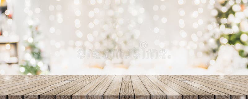 Empty woooden table top with abstract warm living room decor with christmas tree string light blur background with snow,Holiday