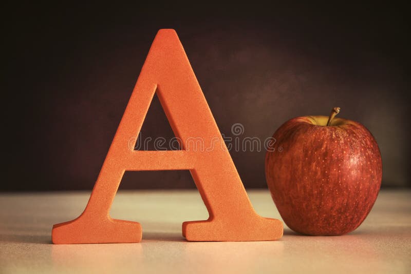 Letter A with an apple on table