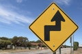 Black and yellow road sign warning of Sharp Turn To The RIght, Then Sharp Turn To The Left ahead