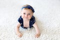 Cute adorable baby girl in blue clothes and headband.