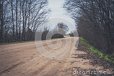 Sharp turn with warning sign on a gravel road. Stock Photo