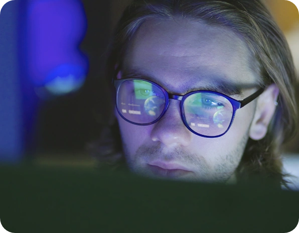 Man with glasses looking at laptop