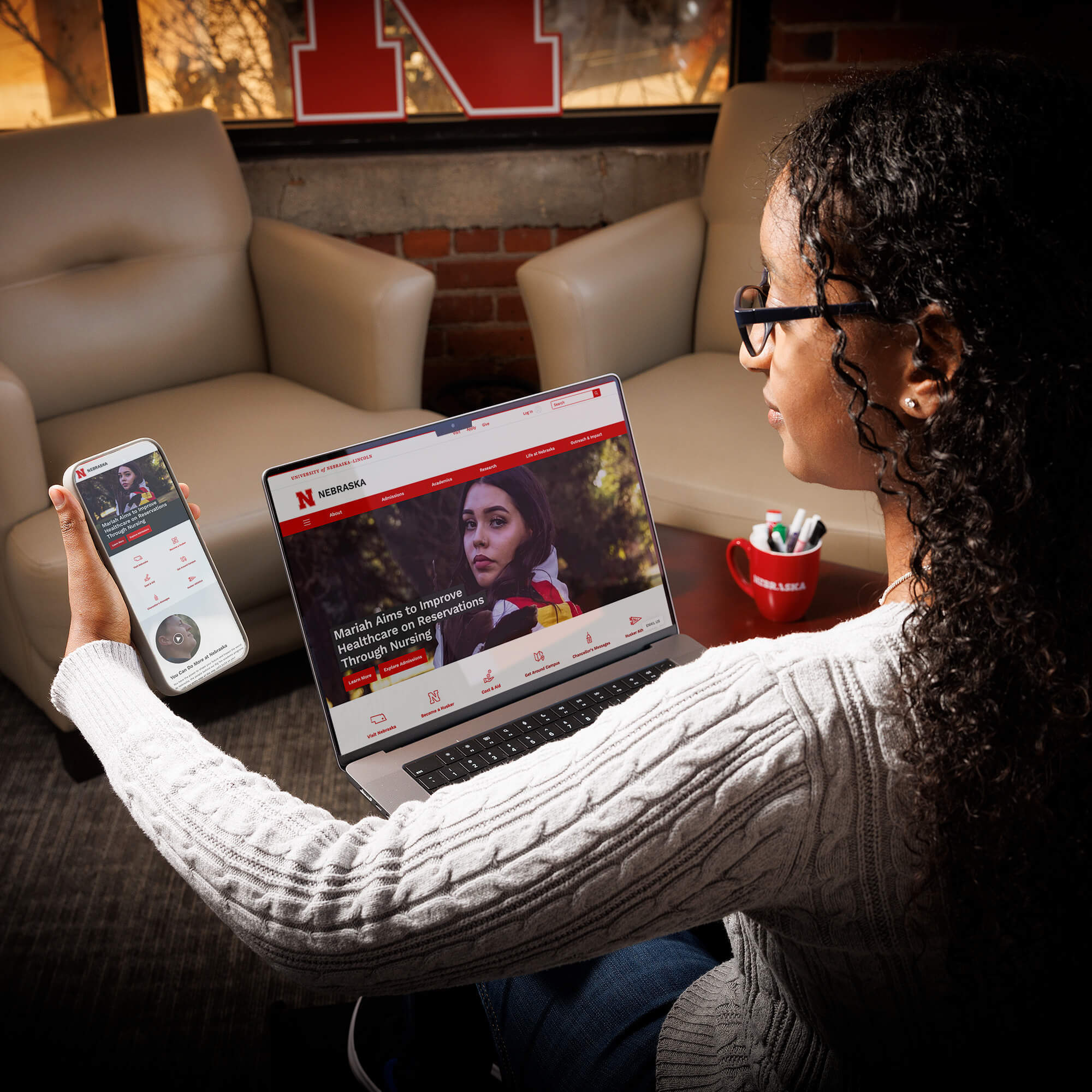 User holding a smartphone and comparing website to desktop version