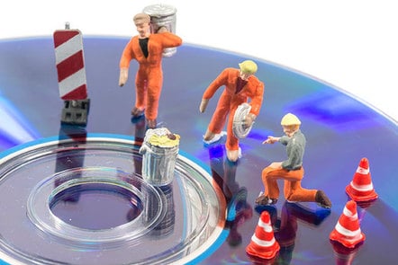 Tiny plastic workmen with dustbins working on a CD. They have tiny plastic cones.