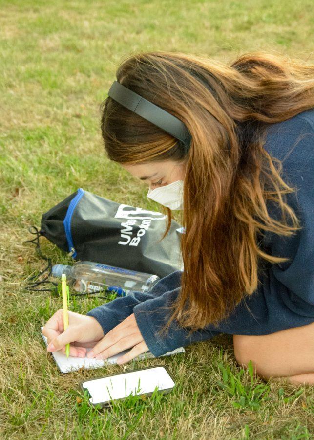 A student takes time to journal the day after her move into the residence halls on Thursday.