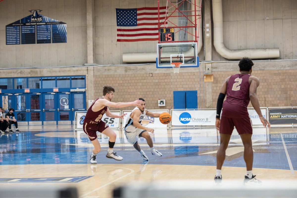 Guard Emanuel Zayas dribbles the ball on the court. Photo by Dong Woo Im / Mass Media Staff.