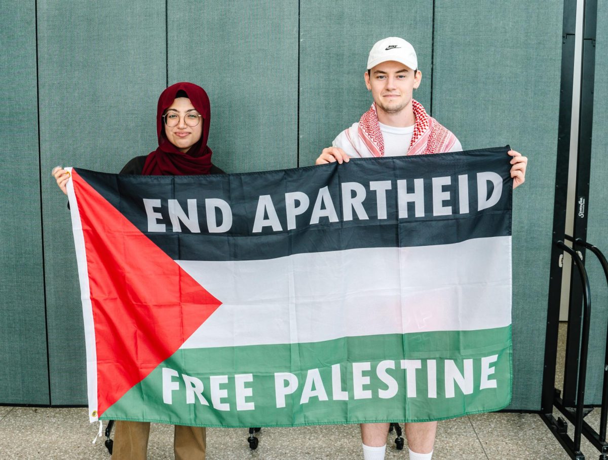 Two members of Students for Justice in Palestine hold a "Free Palestine" flag during educational events hosted by the club for Israeli Apartheid Week. Photo by Olivia Reid / Photography Editor