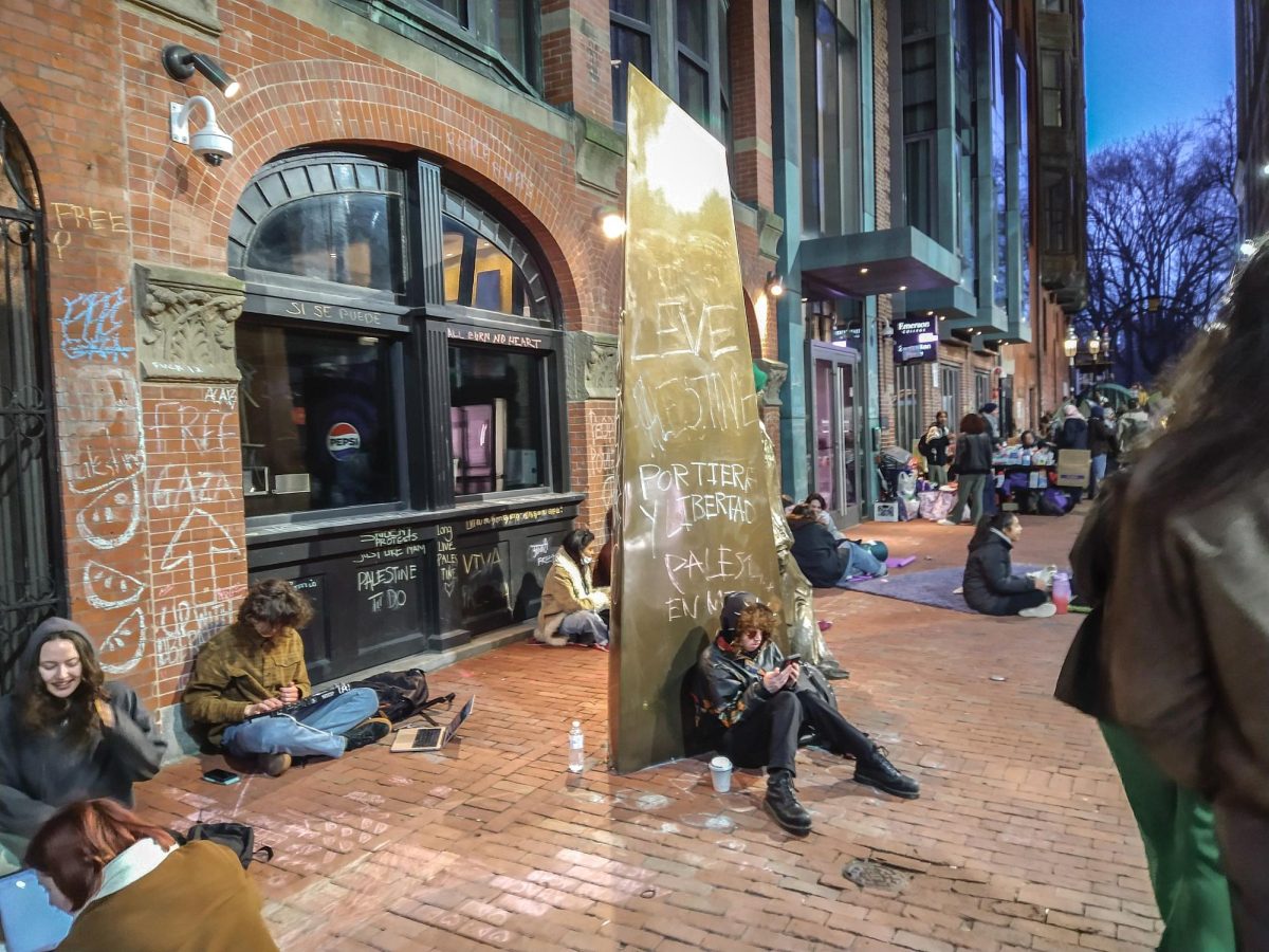 Students at Emerson College's encampment for Palestine sit and talk outside a campus building. Photo submitted by Elijah Horwath / Mass Media Staff