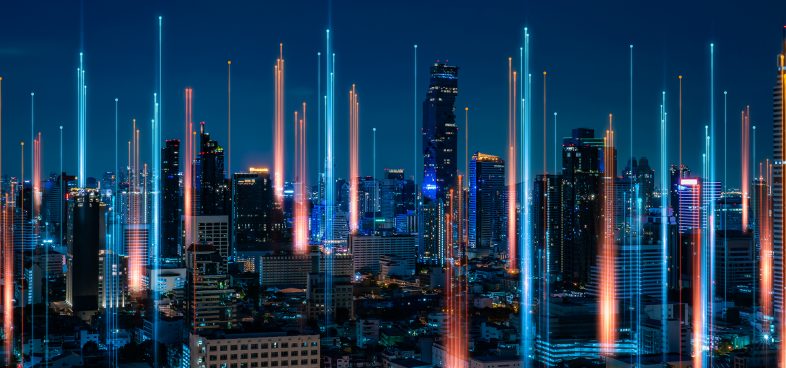 A cityscape with many highrises at night. From the ground, beacons of light point upward and end in glowing dots.