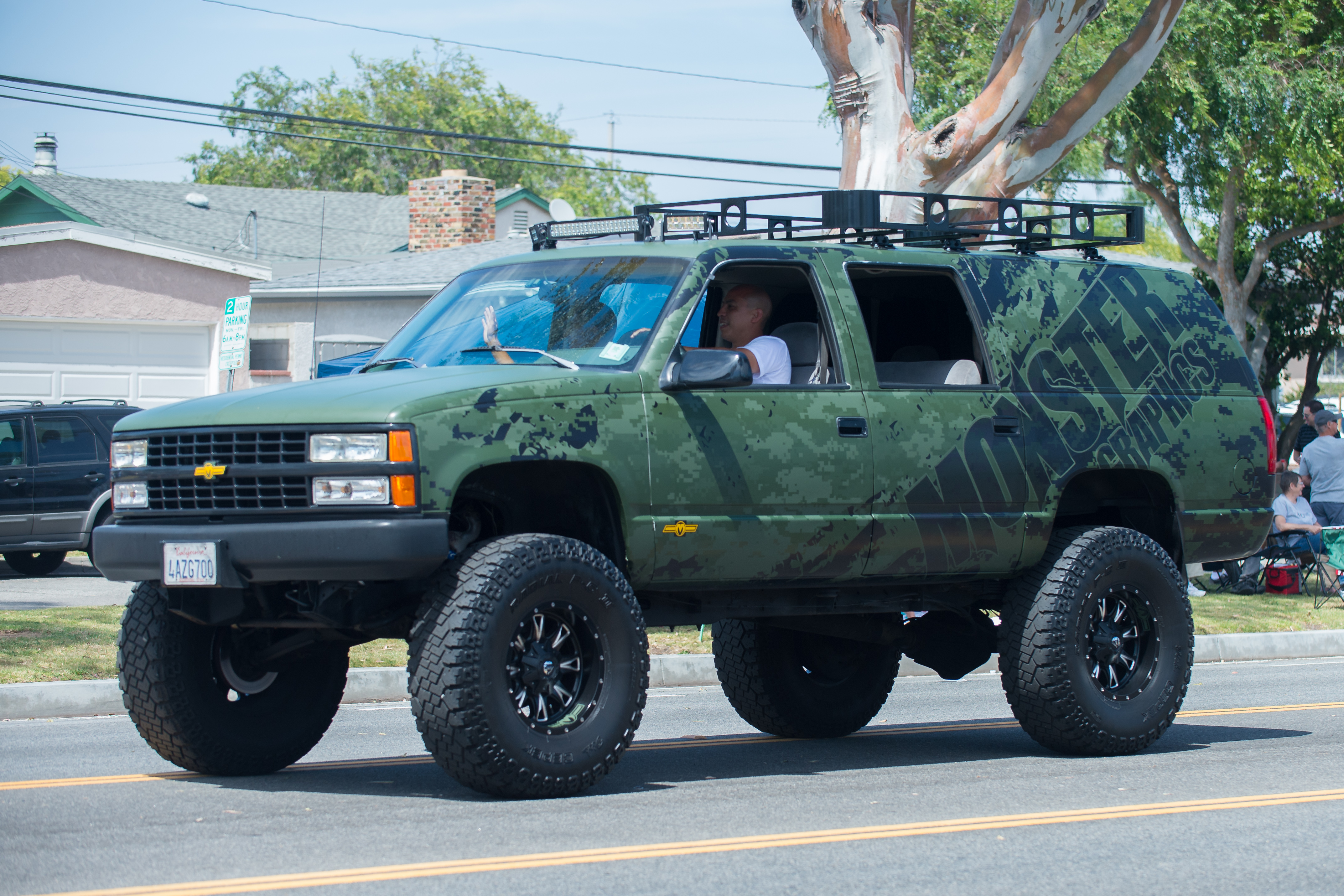 Chevrolet Suburban raised with aftermarket wheels and suspension mods – note much greater ground clearance under front with independent suspension, compared to under rear live axle differential.