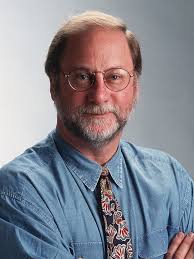 photo of Jim Willse wearing glasses, a blue shirt and tie, arms folded