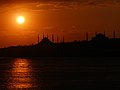 Sun setting over the Bosphorus with Hagia Sophia and the Blue Mosque in the back.