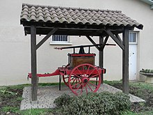 Photographie de la pompe à bras des pompiers sous un abri.