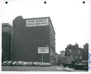 Large, windowless wall with cars parked