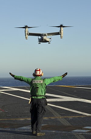 "An MV-22 Osprey assigned to Marine Medium Tiltrotor Squadron (VMM) 165 lands on the flight deck of the aircraft carrier USS Nimitz (CVN 68)."