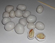 White-coated peanuts. One has been split open to show the peanut inside.