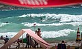 Surfers and beachgoers on a busy summers day