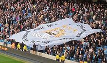 Tifo porté par les supporters de Manchester City au bord de la pelouse.