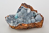 Een geode met kleine kwartskristallen op een basislaag van limoniet.