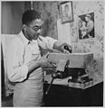 Sculptor Leslie Bolling carving a sculpture, n.d.