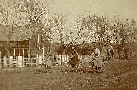 Women on bicycles on unpaved road, US, late 19th century