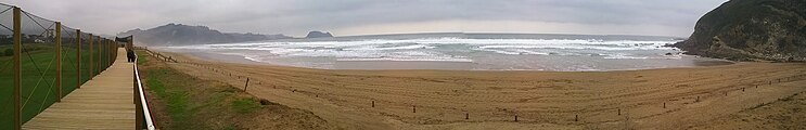 Zarauzko hondartza eta Iñurritza biotopo babestuaren ikuspegi panoramikoa, atzealdean, urrutira, Getaria eta San Anton mendia edo Getariko arratoia