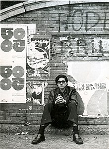 Carlos Mesa sits in front of a wall