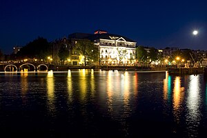 A view of Carré Theater and the River Amstel in Amsterdam by moonlight.