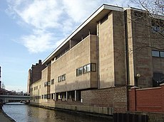 Low level view of a light coloured building alongside a canal