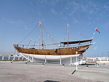 An Arabian dhow, a ship constructed with a covered area at the rear and no real superstructure. Used as cargo vessels, they have one or two masts with triangular sails.