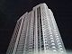 Ground-level view of a 45-story tower at night; the building, which is lit up, has a rectangular cross section and a white facade.