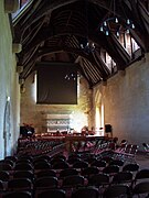 Grand hall médiéval avec ses charpentes à blochets saillants.