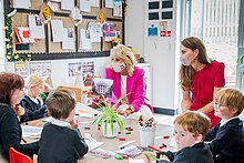 Catherine dan Jill Biden berinteraksi dengan anak-anak sekolah di meja sambil mengenakan masker