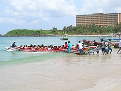 Abfahrt einer Piroge vom Strand von Ngor zur Insel Ngor; im Hintergrund das Hotel Ngor