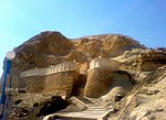 A hill with some walls and steps leading to a mosque