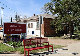 Olney Springs' town hall and welcome sign.