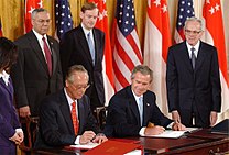 Prime Minister Goh Chok Tong and U.S. President George W. Bush signing the US-Singapore Free Trade Agreement in the White House, May 6, 2003. In the background Robert Zoellick and Colin Powell SingaporeUS FreeTrade.jpg