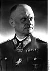 A man wearing a military uniform and a neck order in the shape of a cross.