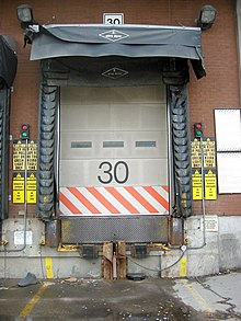 Truck loading dock with overhead door, dock leveler, dock seals, canopy, indicator lights, and truck restraint system. Loading dock.jpg