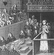 À la droite du dessin en noir et blanc se tient une jeune femme habillée d'une robe et d'un bonnet qui se tient debout à la barre d'un tribunal. La pièce est remplie d'hommes portant une perruque.