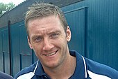 A portrait photograph of a blond man in sports-training attire.