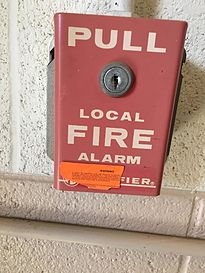 A Notifier pull station at Oklahoma State University. The orange sticker on it warns would-be pranksters of the consequences of false alarms.