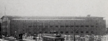 Black-and-white photograph of the Des Moines Coliseum, a flattish rectangular building with many windows and a low-angles roof. Seems to have perhaps three stories.