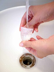 Washing a menstrual cup under a stream of fresh water in a sink 3.jpg