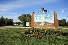 The town sign, featuring "Big Bert", the prehistoric Crocodile found on the banks of the Carrot River, on the edges of town. CarrotRiver TownSign 5879.jpg