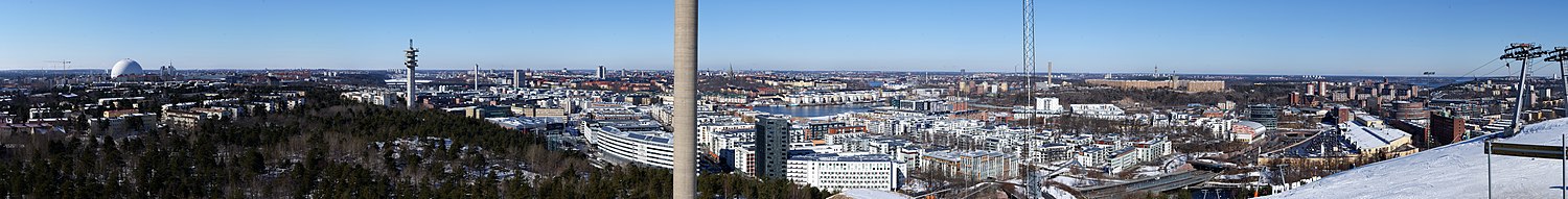 Panorama över Söderort och Hammarby sjöstad från Hammarbybacken. Skorstenen i bildmitt tillhör Henriksdalsverket.