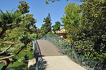 Photographie d'une allée du Jardin Public entourée de buissons verdoyants.